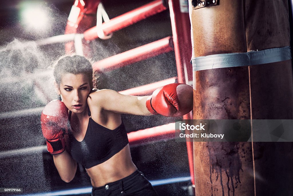Kobieta bokser szkolenia z Worek treningowy - Zbiór zdjęć royalty-free (Boks - sport)
