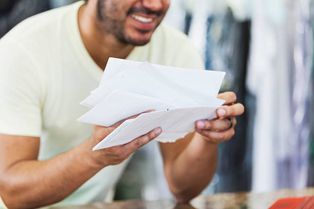 istock Hispanic man working in dry cleaners opening mail 509182398