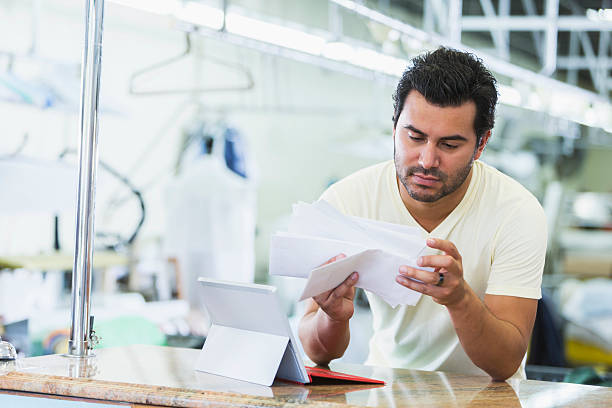 Hispanic small business owner, dry cleaner paying bills