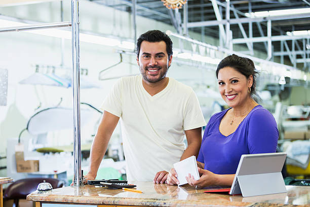 Hispanic small business owners, dry cleaner paying bills