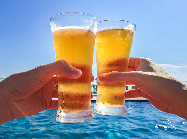 Two men enjoyed there summer vacation with their beer by poolside