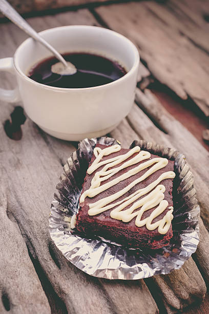 Cake chocolate brownie and hot coffee on old wooden background.