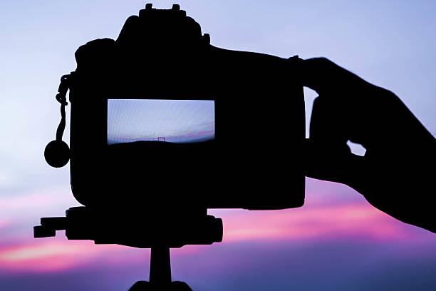 istock Photographer's Hand and DSLR camera focus on sunrise lanscape sc 509187168