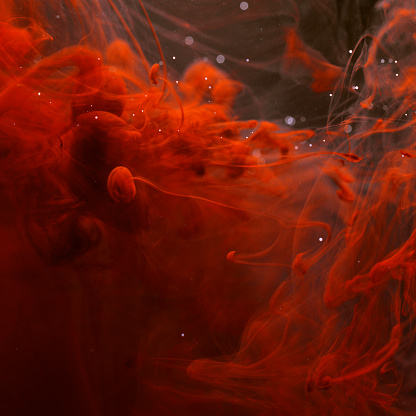 Colors dropped into liquid and photographed while in motion. Ink swirling in water.