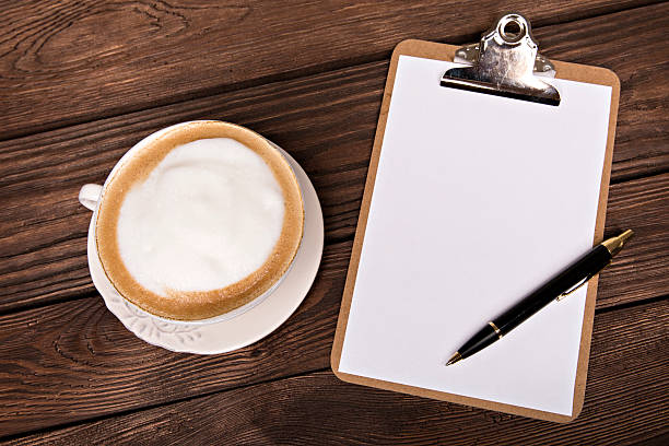 High Angle View Of Coffee With Food And Diary On Wooden Table