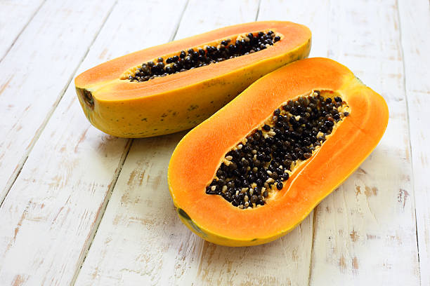 istock Sliced fresh papaya on white wooden background 509197290