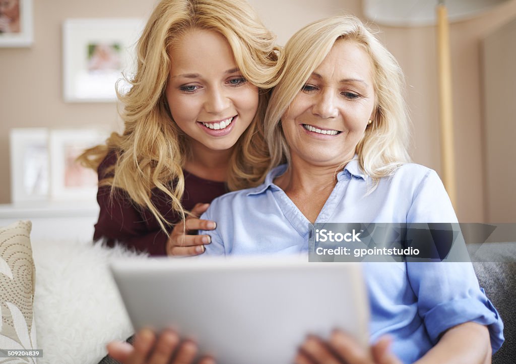 Loving mom and daughter enjoying wireless internet Teenage Girls Stock Photo