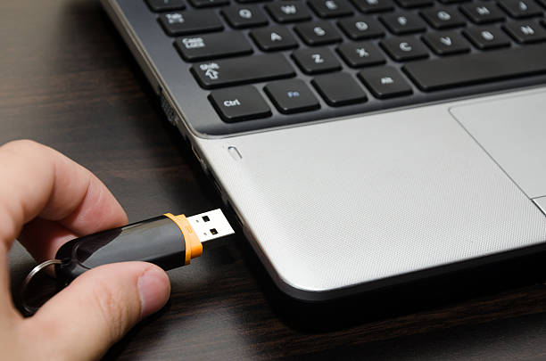 mano inserción de unidad flash usb en computadora portátil puerto primer plano - dispositivo de memoria usb fotografías e imágenes de stock