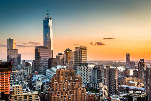 Lower Manhattan at sunset Lower Manhattan skyline at sunset with Freedom Tower standing tall above the skyline lower manhattan photos stock pictures, royalty-free photos & images