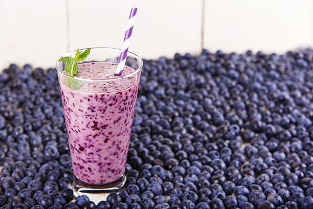 czarna jagoda smoothie w szklanym słoju z słomy i mięta - blueberry smoothie glass striped zdjęcia i obrazy z banku zdjęć