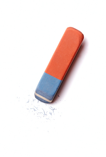 Blue and red eraser or rubber with rubber residue on white conceptual of school, art and office supplies