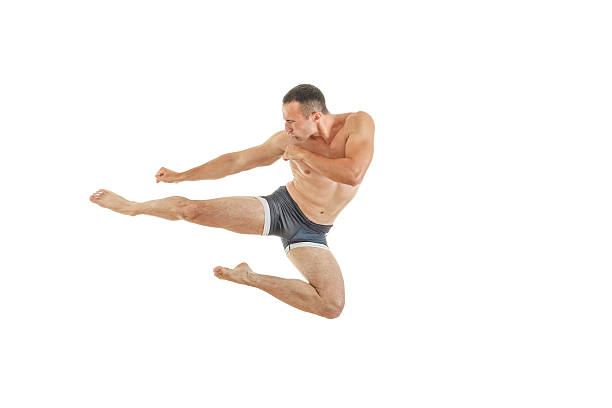 Athletic boxer fighter kicking jumping in the air stock photo