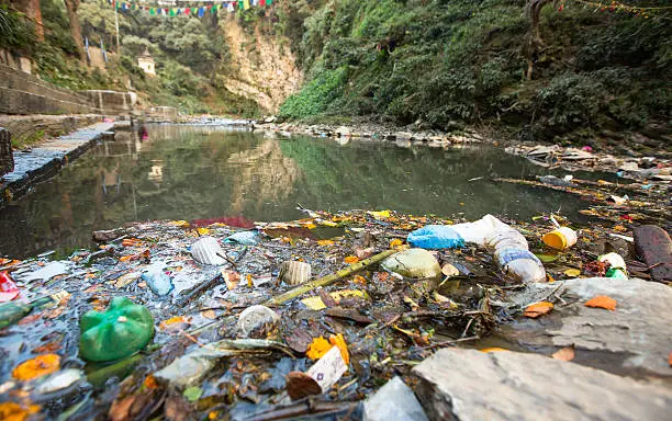 Plastic Contamination into Nature. Garbage and bottles floating on water. Environmental pollution in the Himalayas. Garbage in the water of river Bagmati.