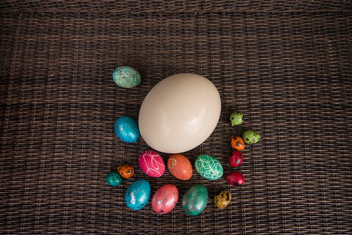 Pile of different sized easter eggs on a rattan background