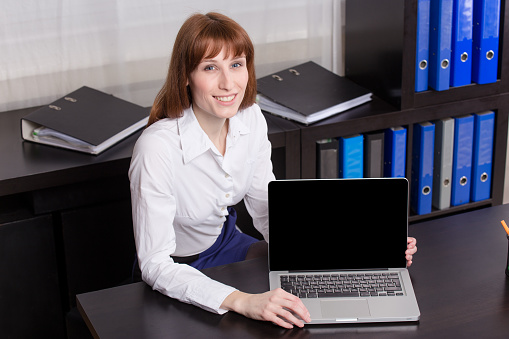 Business woman showing laptop blank screen.