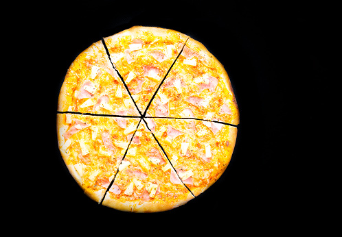 Hawaiian Pizza isolated on black background, studio shot