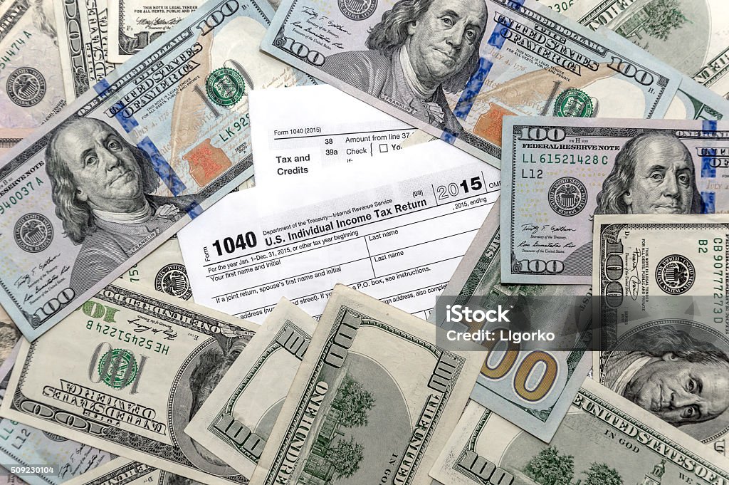 Tax form 1040 with US dollar bills Refund Stock Photo