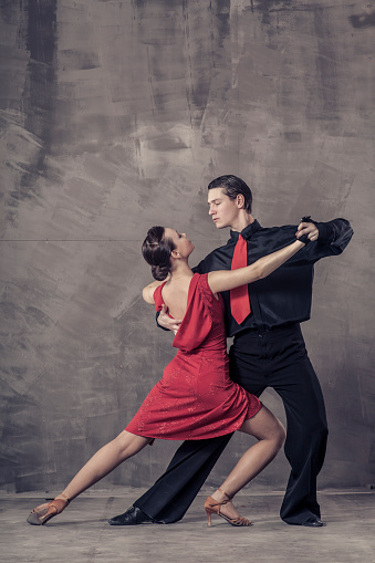 Young couple dancing the Argentine tango in the studio