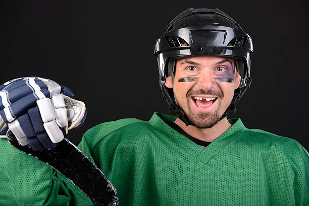 Hockey Funny hockey player smiling, bruise around the eye. Black background gap toothed photos stock pictures, royalty-free photos & images