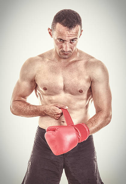 istock muscular man putting his boxing gloves in front of camera 509234437