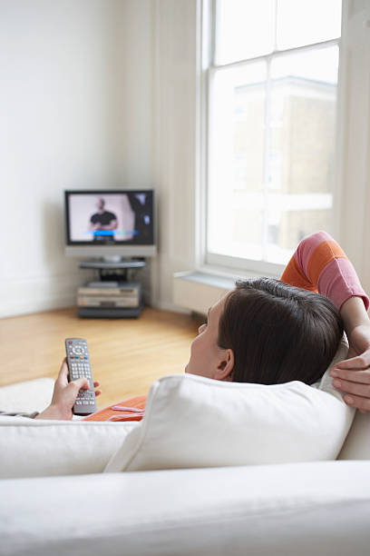 istock Woman On Couch Watching TV 509235551