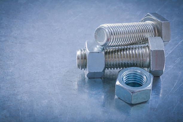 istock Horizontal view of stainless bolts screw-nuts on metallic backgr 509238702