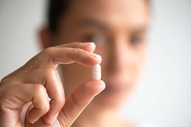 Woman Holding And Showing Medication Capsule