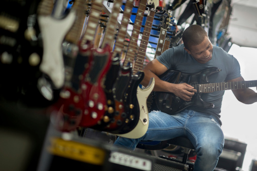 Man playing the guitar at a music store
