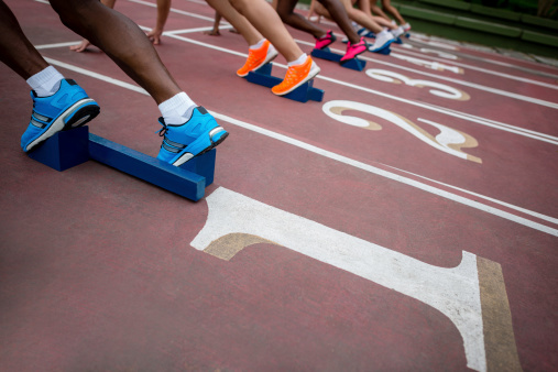 Group of people running at a sports track