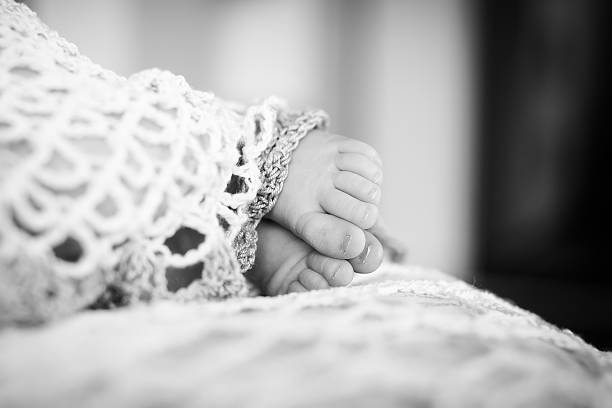 крупным планом картина новорожденный ребенок ноги. черно-белые фото. - human foot baby black and white newborn стоковые фото и изображения