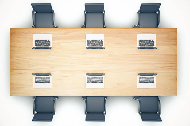istock Top view of wooden meeting table with chairs and laptop 509242578