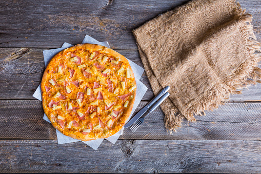 Hawaiian Pizza on a old wooden table