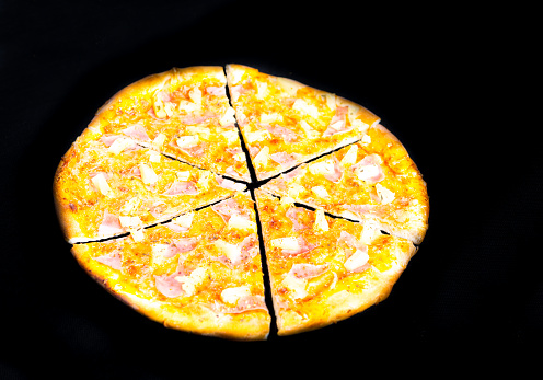 Hawaiian Pizza isolated on black background, studio shot