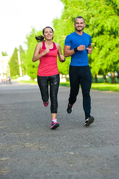 istock Runners training outdoors working out. City running couple jogging outside 509244608