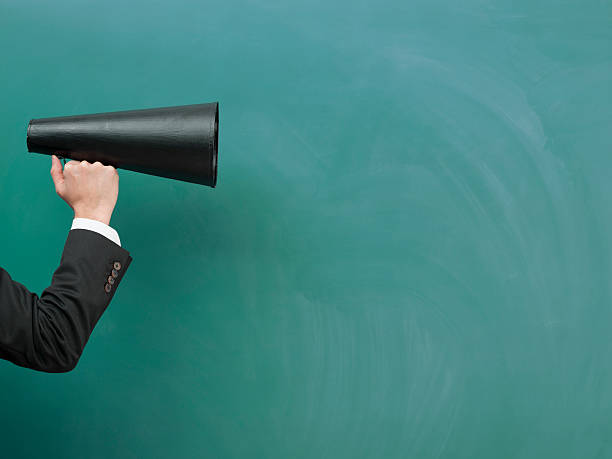 istock Old Fashioned Megaphone In Human Hand On Green Blank Blackboard 509245154