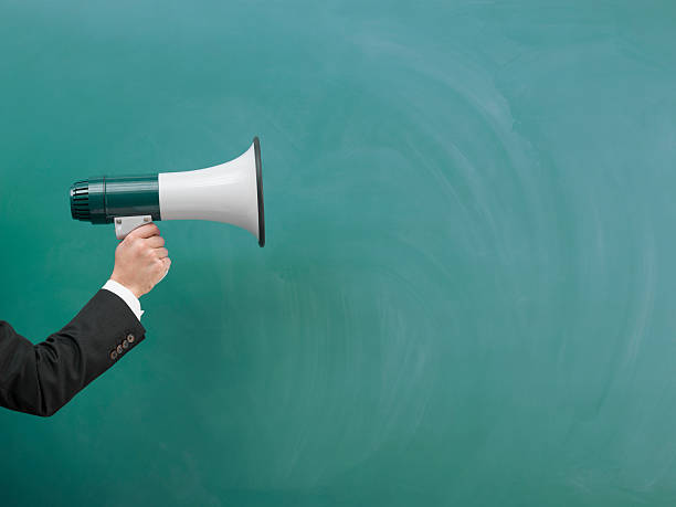 istock Modern Megaphone In Human Hand On Green Blank Blackboard 509245228