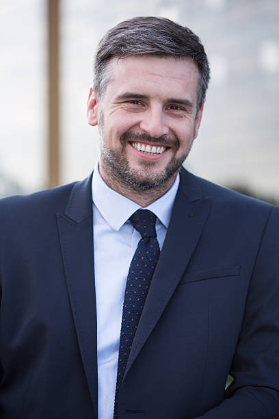 istock Smiling businessman in black suit 509248190