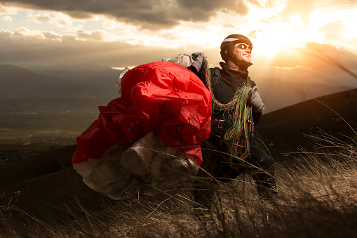 Teen paragliding in mountain on sunset