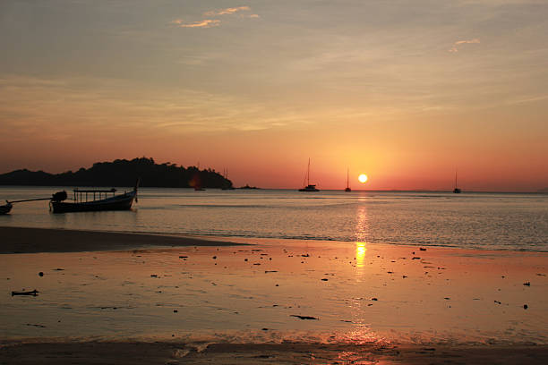 romantic sunset on the beach stock photo