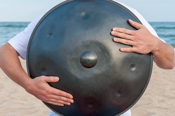 istock Busker on the sand beach and holding a handpan or 509251676