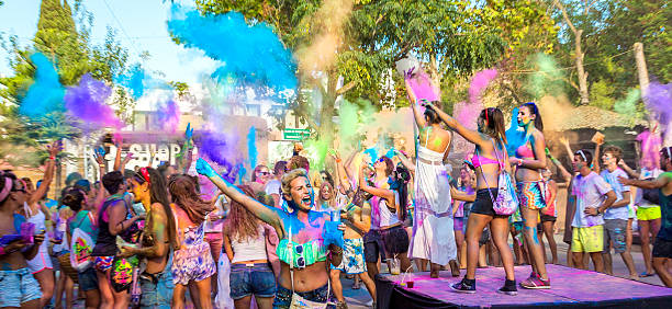 Holi Garden San Antonio, Ibiza, Spain - August 21, 2014: Taken at the Holi Garden Festival in San Antonio, Ibiza.  Hundreds of tourists and holidaymakers make there way to The Holi Garden Festival in Ibiza every week.  Here we can see a few of the party goers throwing coloured paint at each other.  Holi festivals have events all over the world and are becoming more and more popular.  People can buy bags of coloured powder and every hour they have a countdown, as the timer hits zero everyone is supposed to throw their pain in the air in what is called a "paint explosion". ibiza town stock pictures, royalty-free photos & images