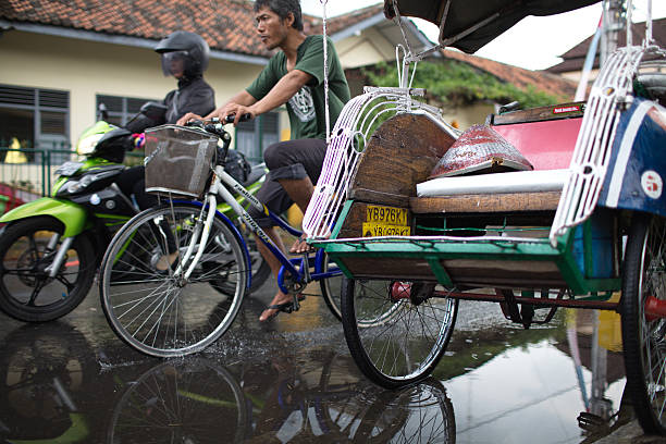 motorcyclist, cyclist and riksha in the center of Yogyakarta stock photo