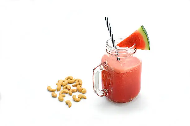 Photo of Water melon smoothie and Cashews on white background