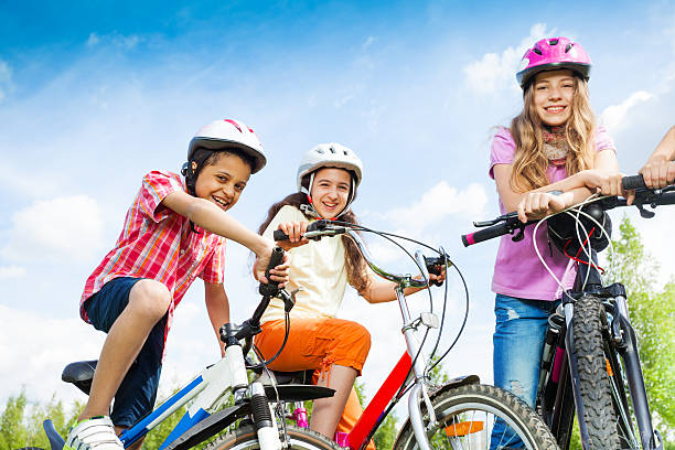istock Laughing kids in helmets hold bike handle-bars 509255195