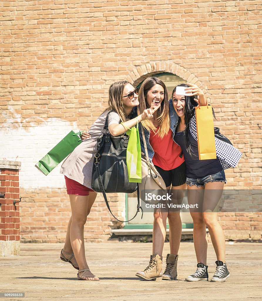 Group of happy best friends with shopping bags taking selfie Group of happy best friends with shopping bags taking a selfie in the city center - Girlfriends walking and having fun in the summer around the old town - University students during a break in a sunny day Shopping Stock Photo