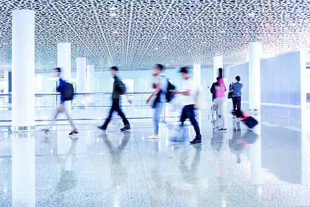 istock motion blurred travellers walking in modern airport hallway 509256848