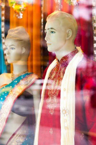 Kuala Lumpur, Malaysia - March 18, 2011: View of a shop window including bright traditional Malay clothing in central Kuala Lumpur with reflections from the outside of the glass