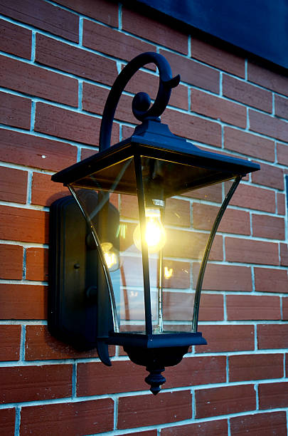 istock Black metal lamp on brick wall with climbing ivy plant 509277557