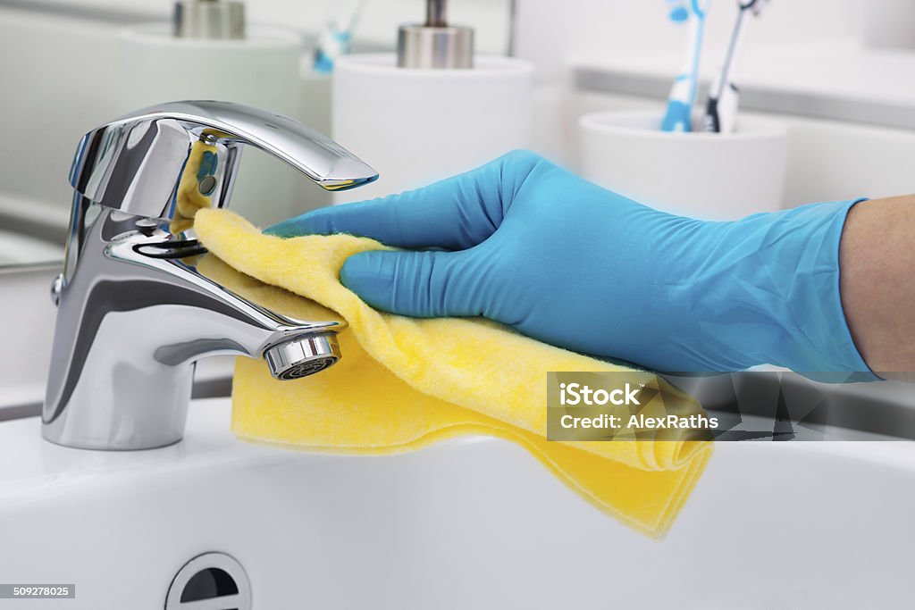 Cleaning Tap Woman doing chores in bathroom, cleaning tap Activity Stock Photo