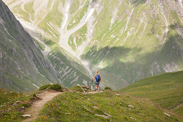 young girl with backpack hiking in the french alps